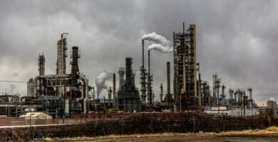 factories with smoke under cloudy sky